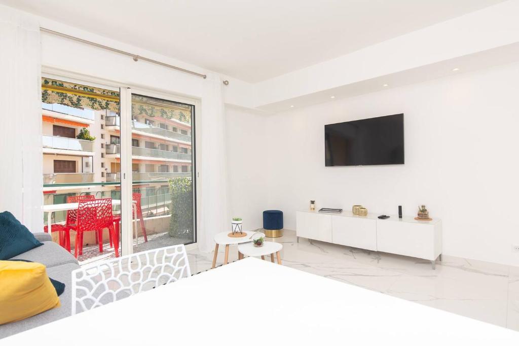 - un salon blanc avec une télévision murale dans l&#39;établissement Brand new 2 bedrooms next to Croisette !, à Cannes