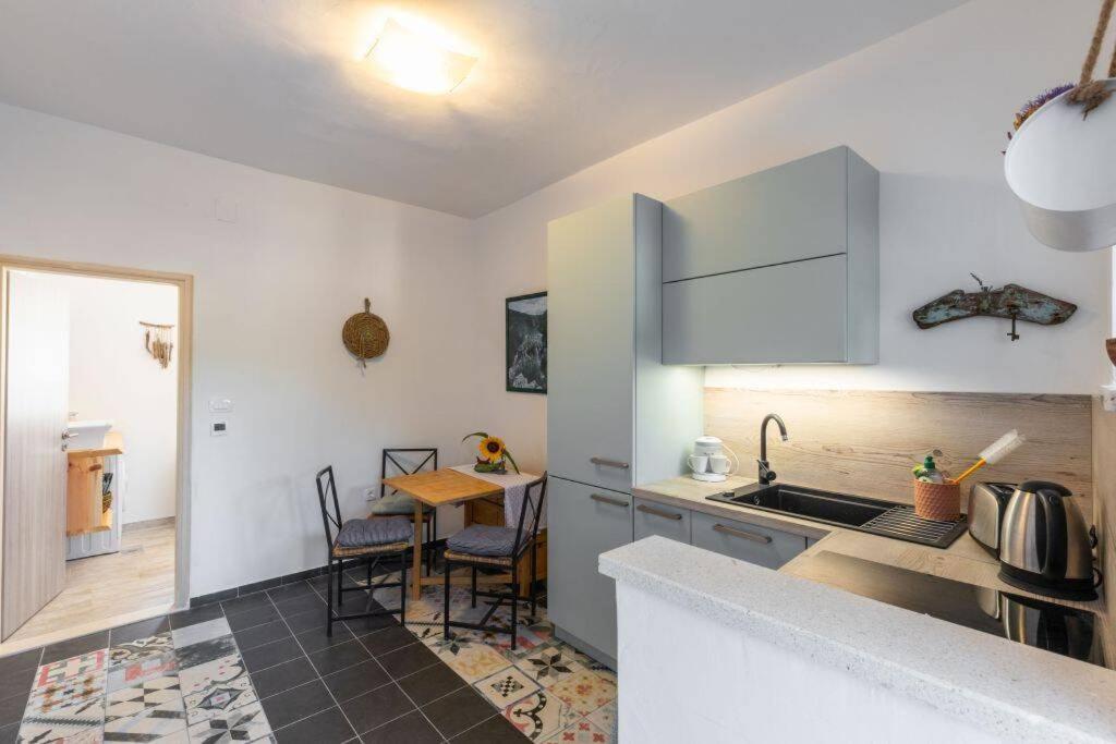 a kitchen with a sink and a table with chairs at Apartment Amula in Korčula