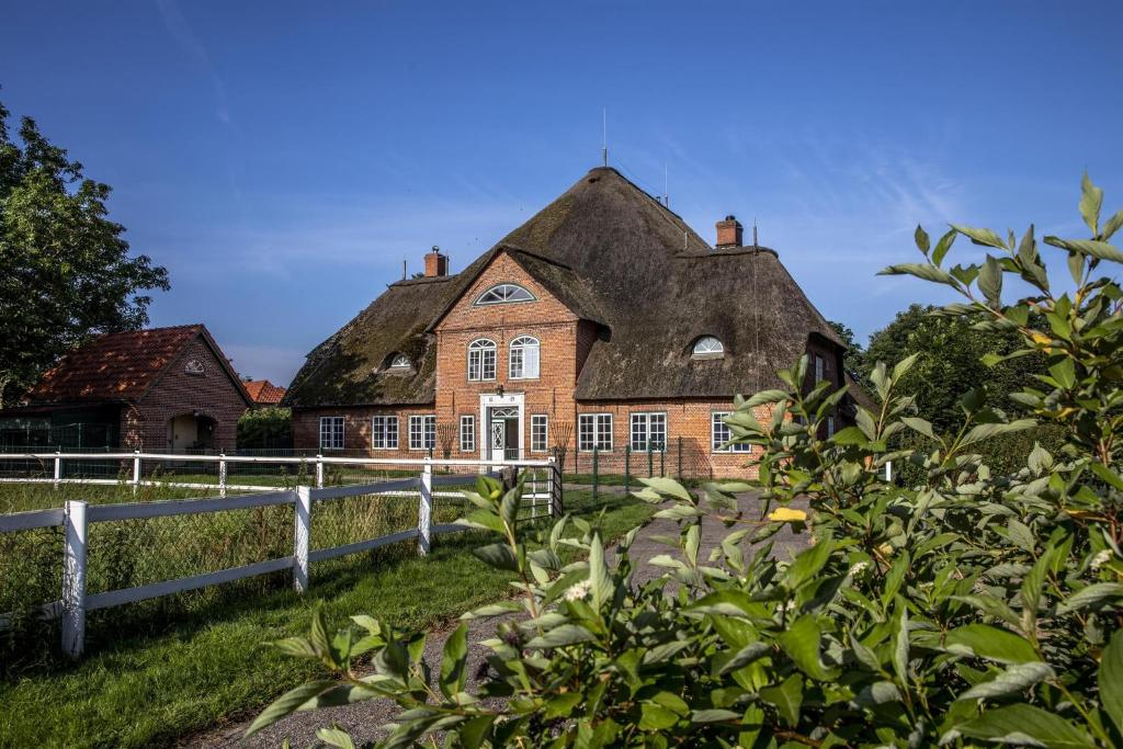 an old brick house with a thatched roof at Haubarg am Meer in Vollerwiek