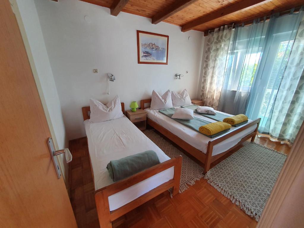 sypialnia z dwoma łóżkami i oknem w obiekcie Apartman Lu w mieście Vir