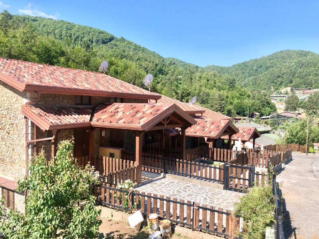 uma casa com uma cerca em frente a uma montanha em Baite Palumbosila em Cotronei