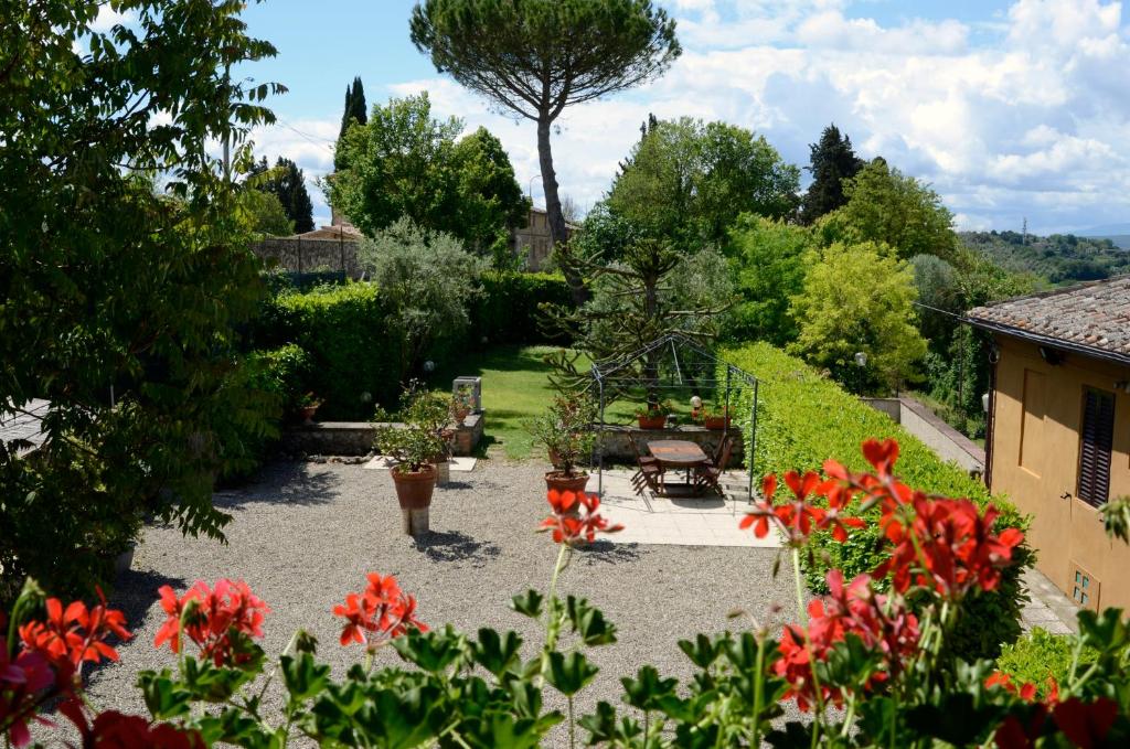 シエナにあるLe case del conventino di Marcianoの赤い花の庭園、テーブルと椅子