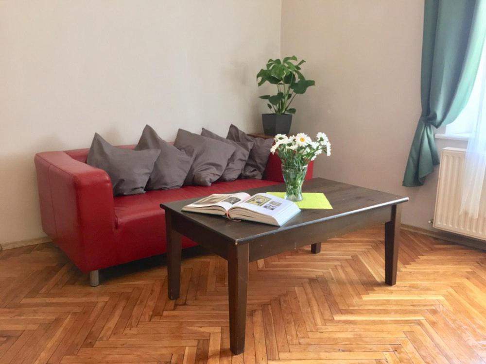 salon z czerwoną kanapą i stolikiem kawowym w obiekcie Green House w Krakowie