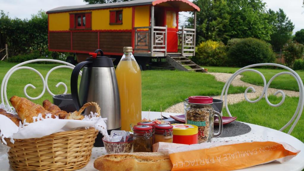 una mesa de picnic con pan y una cesta de comida en La Girardière, en Le Boupère