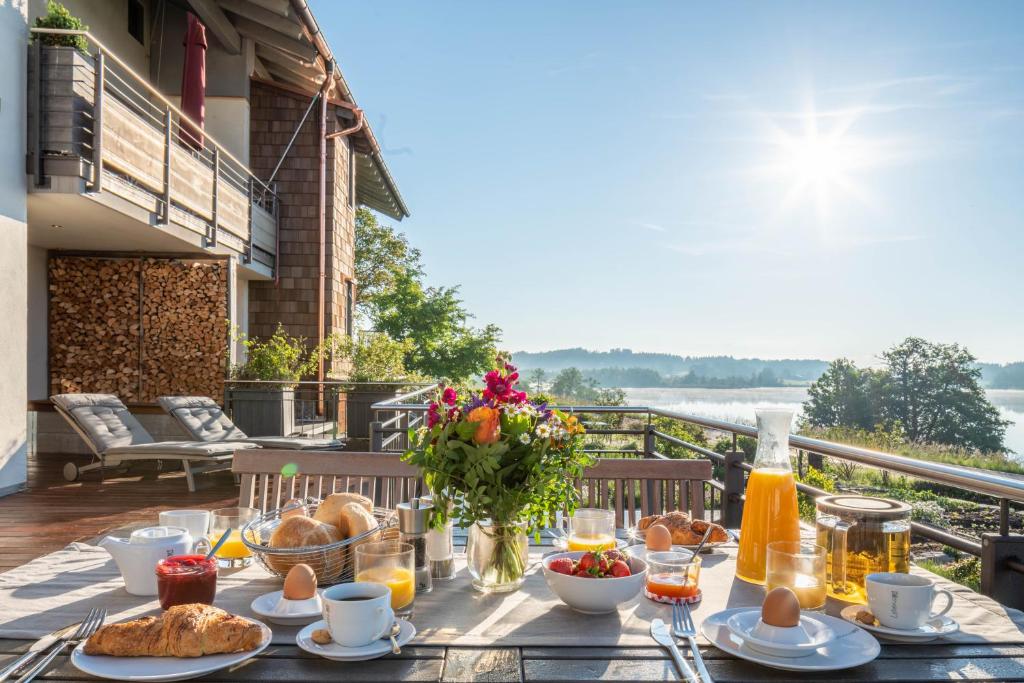 a table with breakfast food on a balcony at Lebensart am See in Bad Endorf