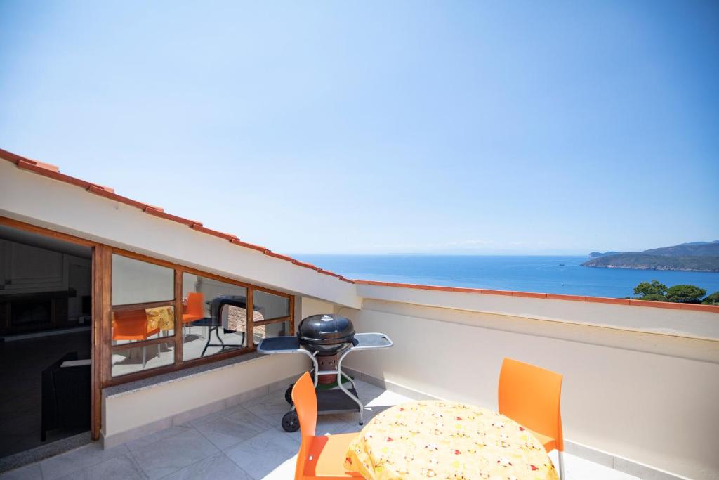 a balcony with a table and a view of the ocean at Casa il tramonto in Capoliveri