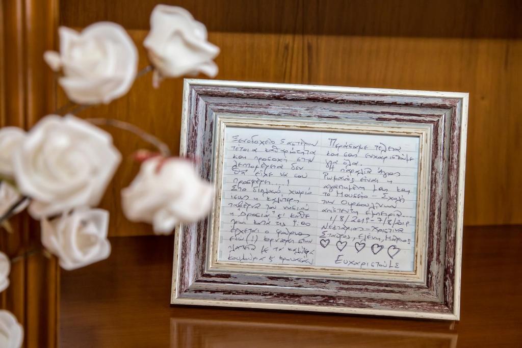 uma fotografia de uma carta num quadro com rosas brancas em Xατζηράδος em Khatzirádhos