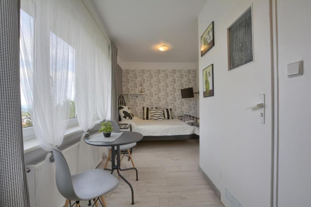 カルパチにあるPensjonat Grańの小さなテーブルとベッドが備わる小さな客室です。