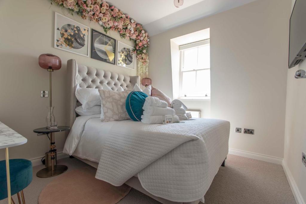 a man sitting on a bed in a bedroom at Beautiful, modern apartment in Hope Place Bath, 1 Bedroom Luxury City Centre Apartment with Beautiful City Views, a stones throw from The Royal Crescent in Bath in Bath