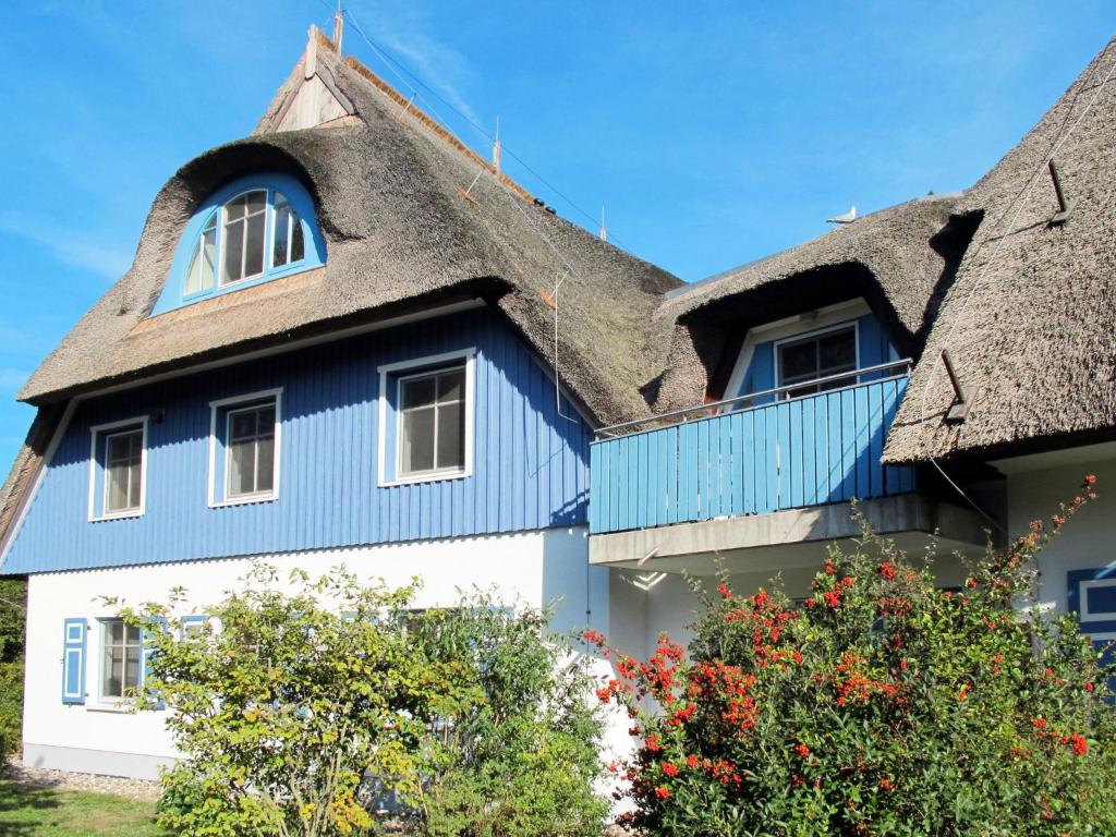 a blue and white house with a thatched roof at Apartment am Haferland by Interhome in Wieck