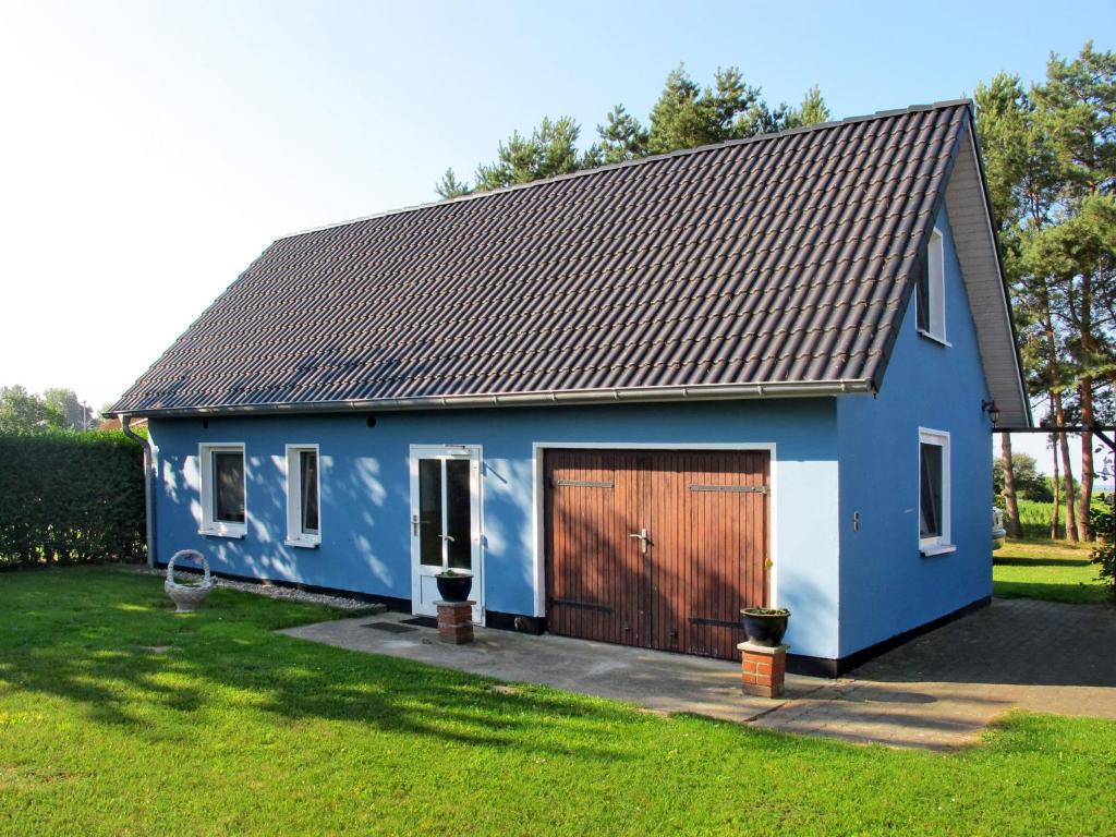 a blue house with a brown garage at Holiday Home Ostwind by Interhome in Ummanz