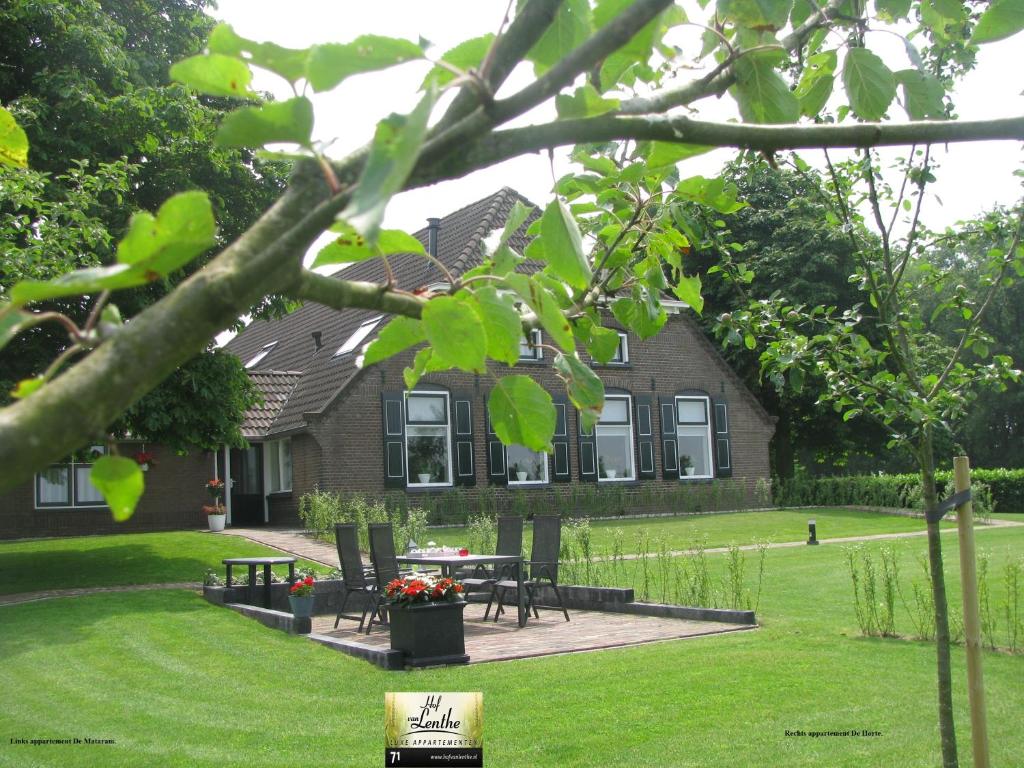 a house with a picnic table in the yard at Hof Van Lenthe appartementen in Dalfsen