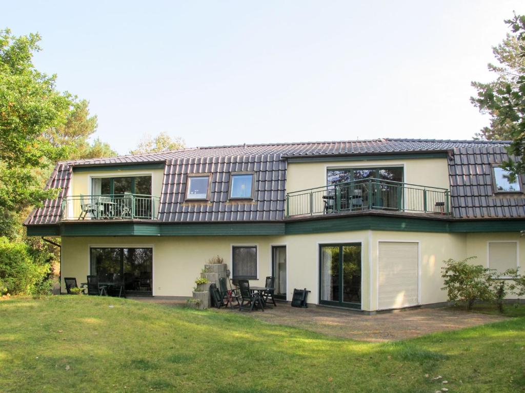 a large house with a balcony and a yard at Apartment Haus Berlin-5 by Interhome in Loddin