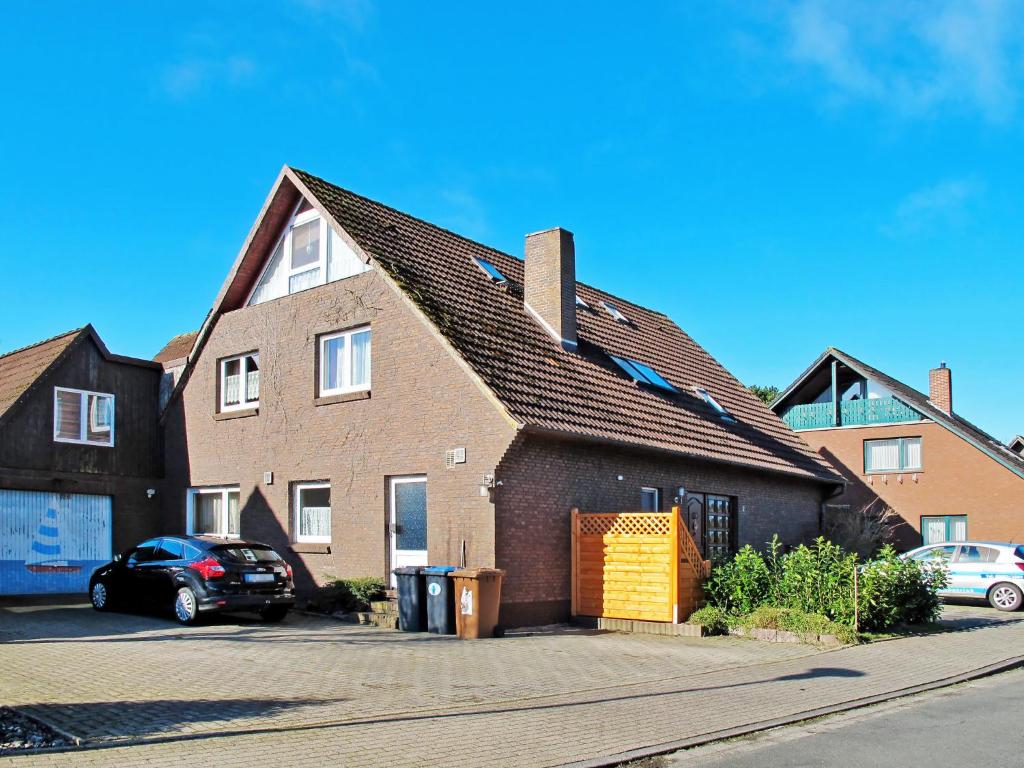 ein großes Backsteinhaus mit gelber Garage in der Unterkunft Apartment Hannemann-2 by Interhome in Schillig