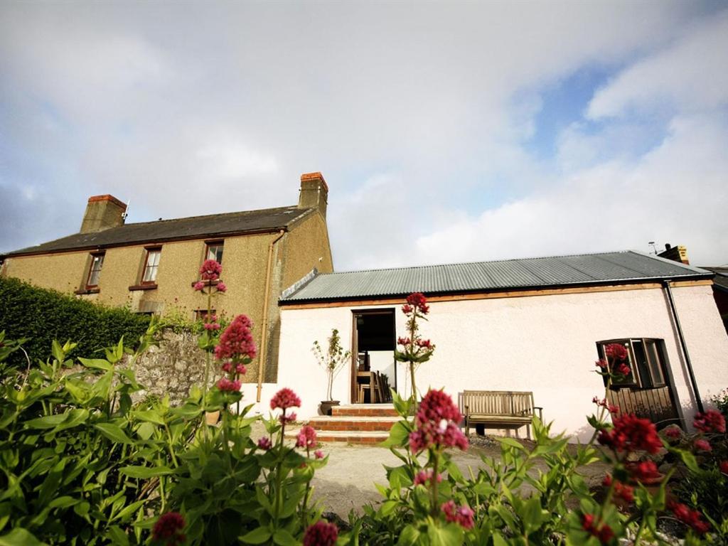 een groot huis met bloemen ervoor bij Blas Gwyr in Llangennith