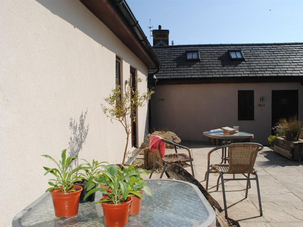 a patio with chairs and a table and a tub at Blas Gwyr in Llangennith