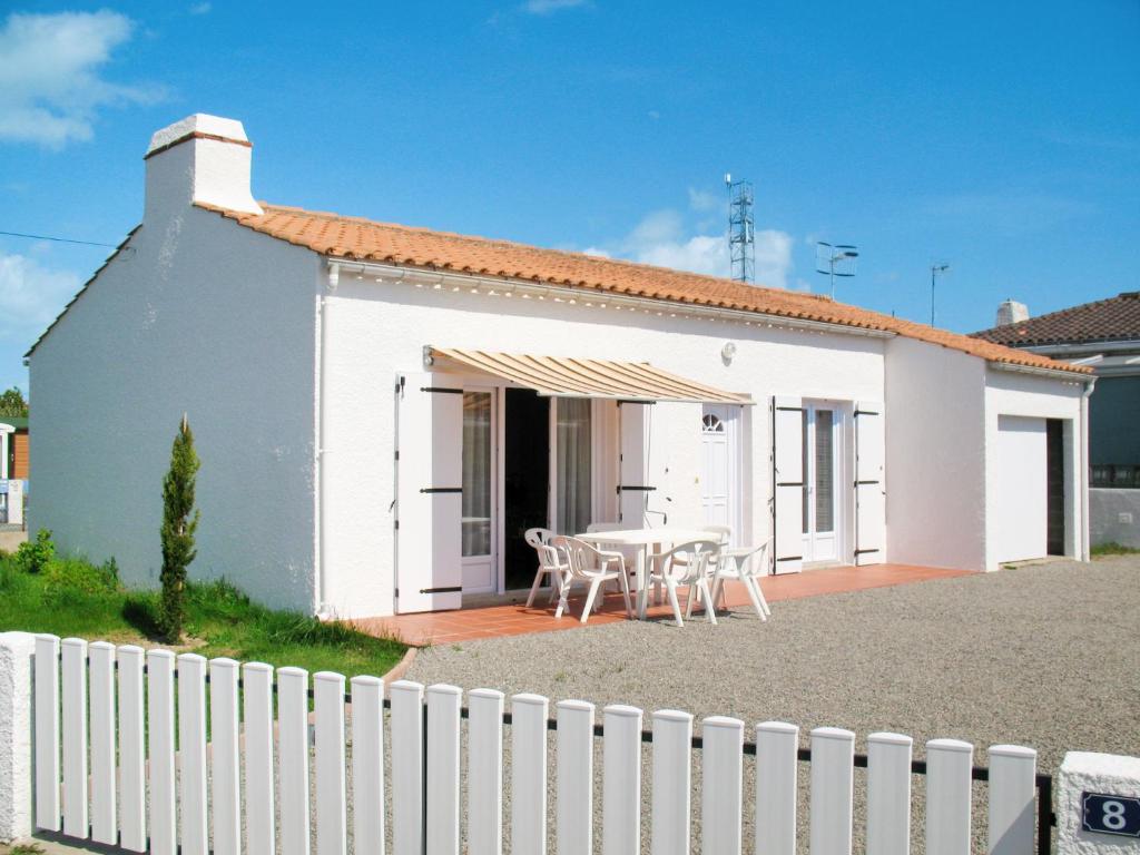 une maison blanche avec une table et des chaises dans l'établissement Holiday Home Le Maupas by Interhome, à La Tranche-sur-Mer