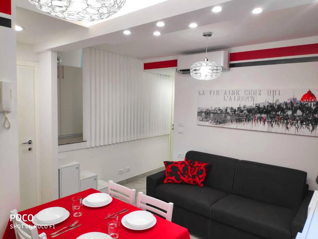 - un salon avec une table rouge et un canapé noir dans l'établissement Logement de Catherine, à Nice