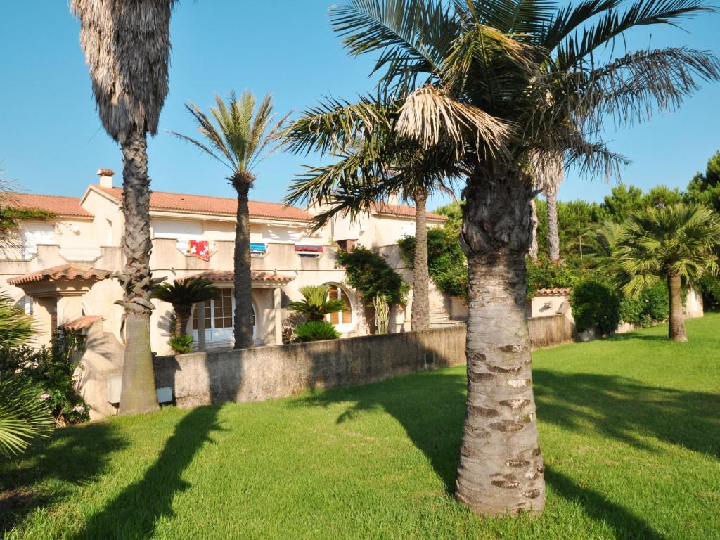 un groupe de palmiers devant une maison dans l'établissement Holiday Home Les Chênes - MAA200 by Interhome, à Borgo