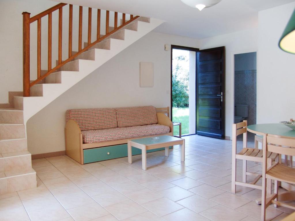 a living room with a couch and a staircase at Holiday Home Les Chênes - MAA200 by Interhome in Borgo