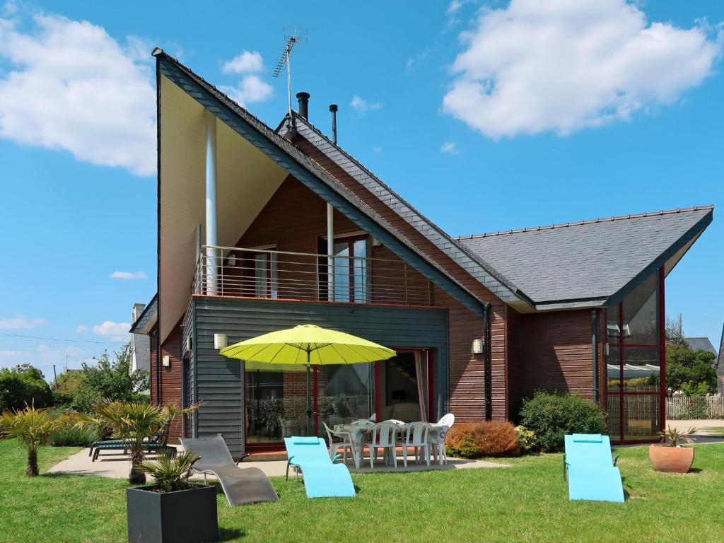 une maison avec un parasol et des chaises jaunes dans l'établissement Holiday Home Ty Annik by Interhome, à Trégunc
