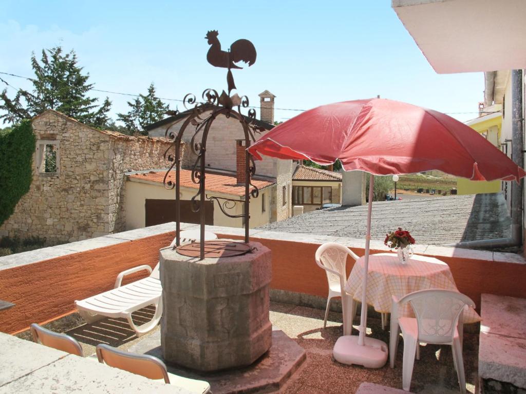 a patio with a table and an umbrella and chairs at Holiday Home Mirjana - PRC420 by Interhome in Vržnaveri