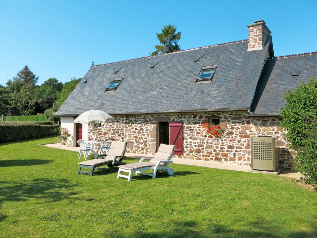 a stone house with two chairs and a table in the yard at Holiday Home La Chevalerie by Interhome in Sourdeval-les-Bois