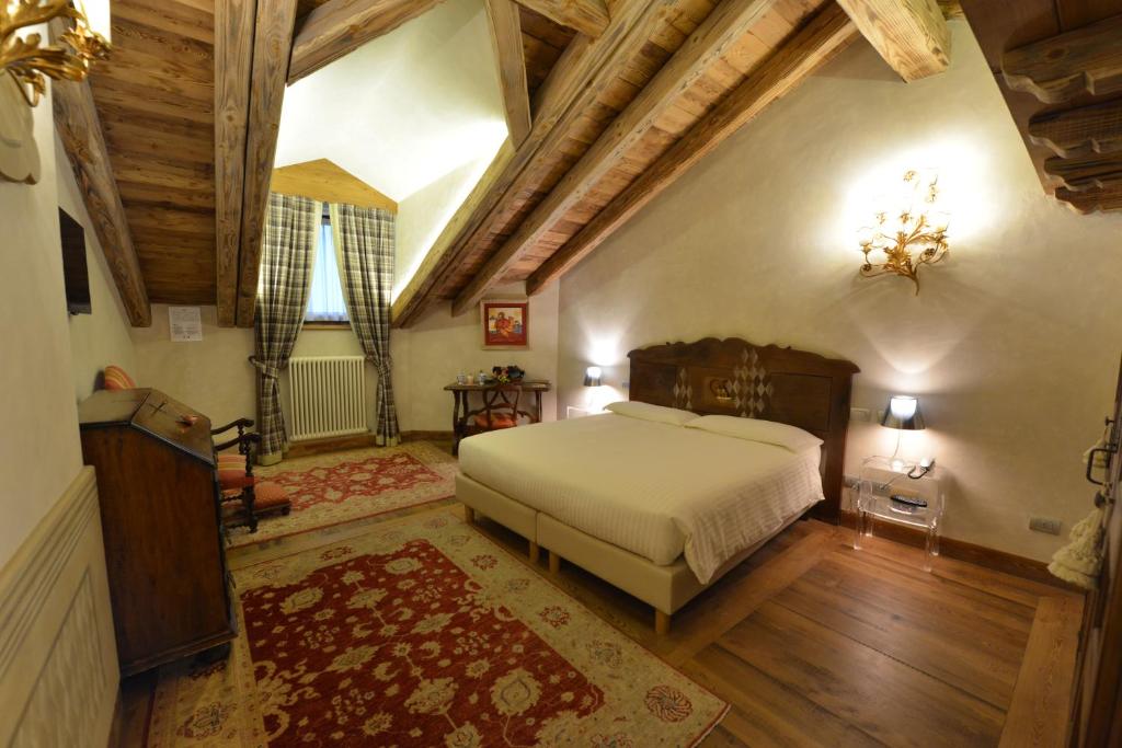 a bedroom with a large bed and wooden ceilings at Le Reve Charmant in Aosta