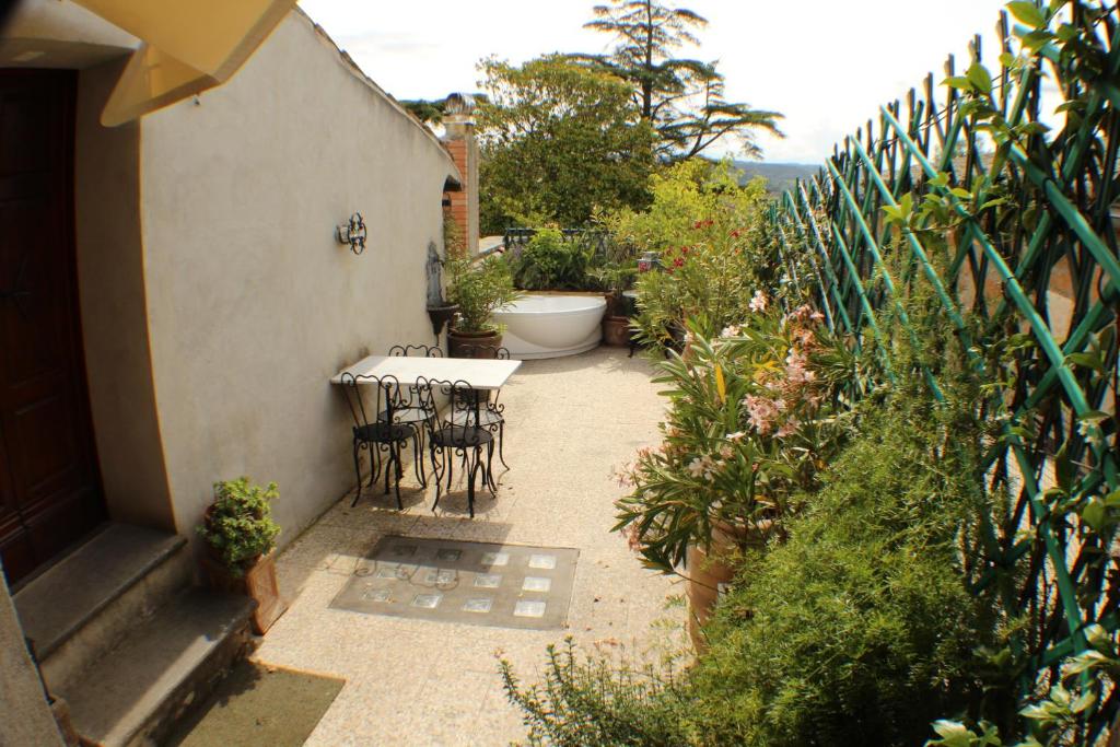 a patio with a table and chairs in a garden at Porta Vivaria Orvieto- Private Parking in Orvieto