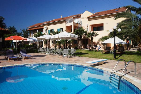 a large swimming pool in front of a house at Poseidon Apartments in Agios Gordios