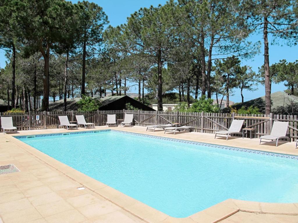 a swimming pool with chaise lounges and chairs at Holiday Home Chalet 2 pers by Interhome in Calvi