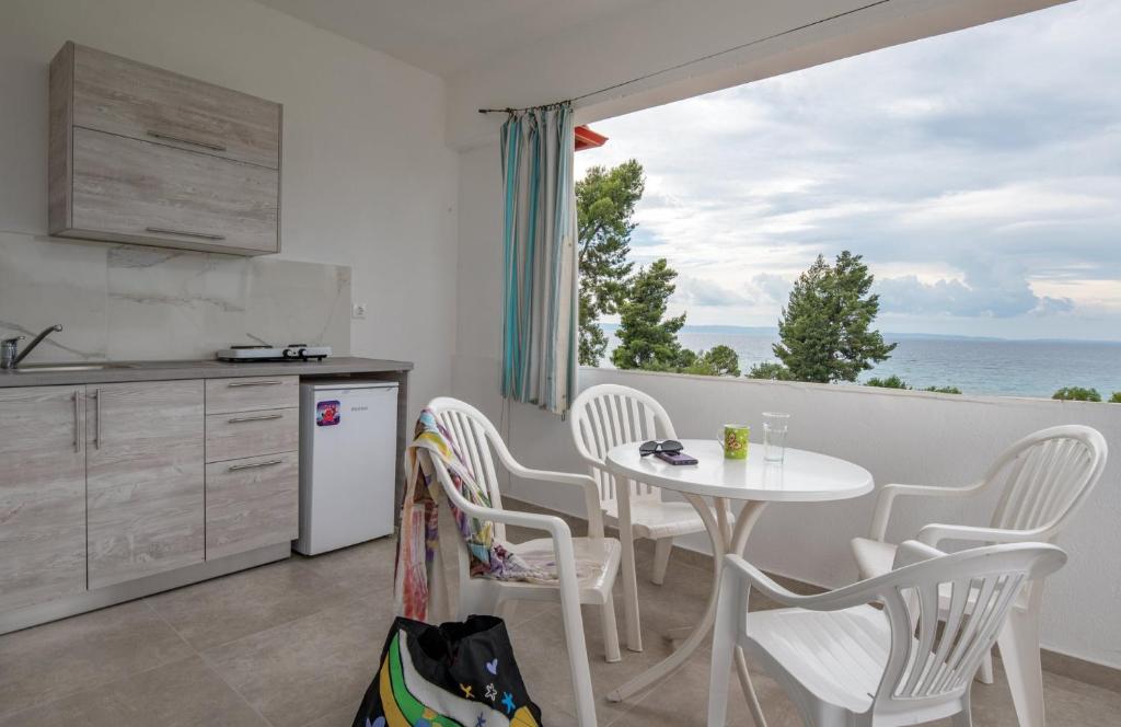 a kitchen with a table and chairs with a view of the ocean at Fantasia Studios and Apartments in Neos Marmaras