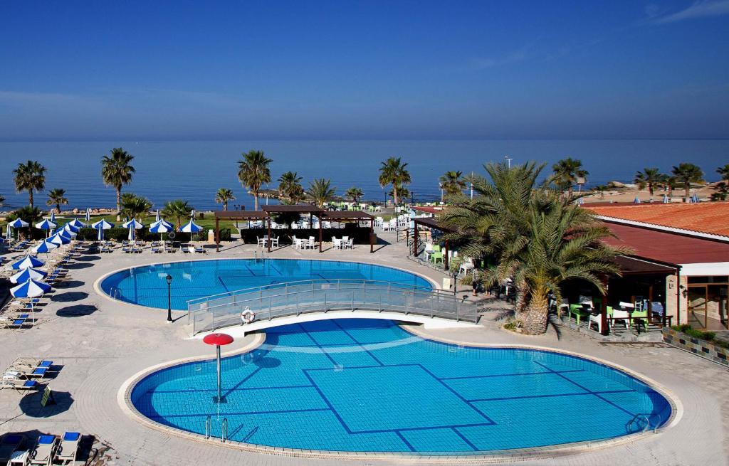 een uitzicht over het zwembad van een resort bij Kefalos Beach Tourist Village in Paphos City