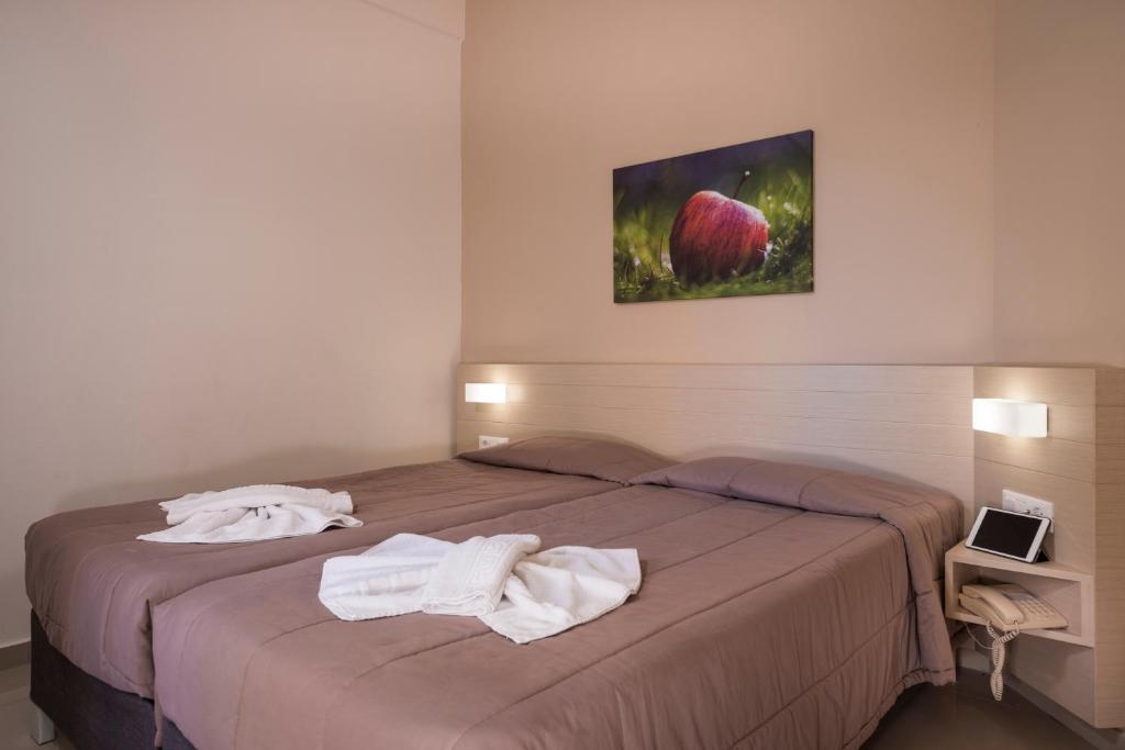 a bedroom with a bed with towels on it at Atrion Resort Hotel in Agia Marina Nea Kydonias