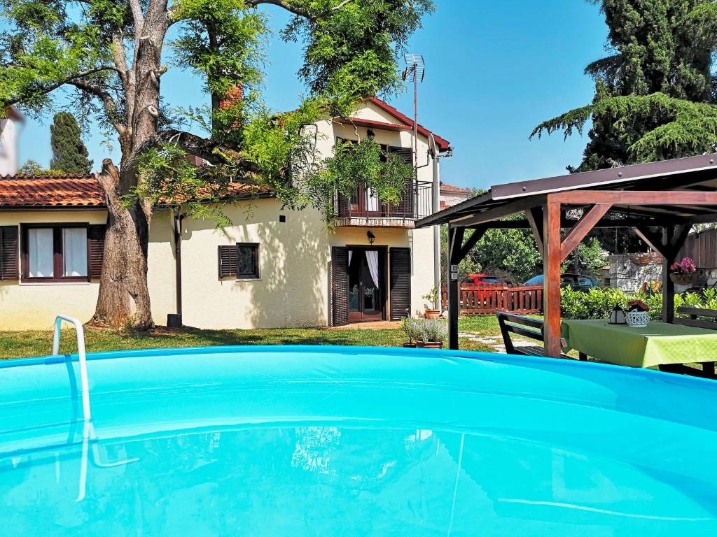 a swimming pool in front of a house at Holiday Home Sara - PRC136 by Interhome in Poreč