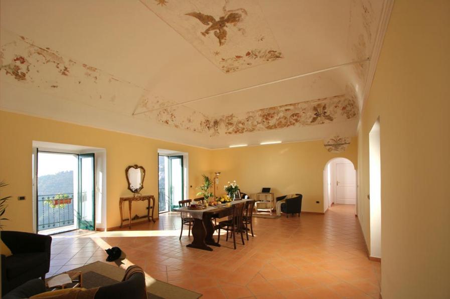a living room with a table and a dining room at Palazzo Verone in Scala