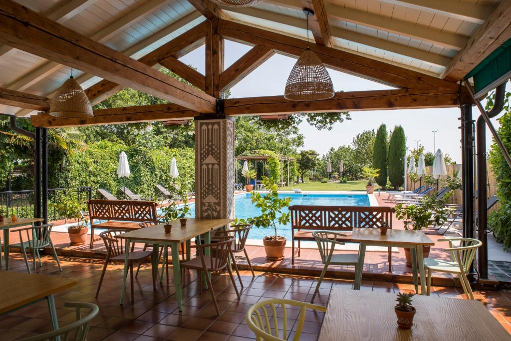 une terrasse avec des tables et des chaises ainsi qu'une piscine dans l'établissement Albergo Mio Boutique Hotel, à Lazise