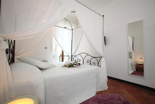 Rooms and Breakfast da Carla في سيستري ليفانتي: غرفة نوم بسرير أبيض مع مظلة