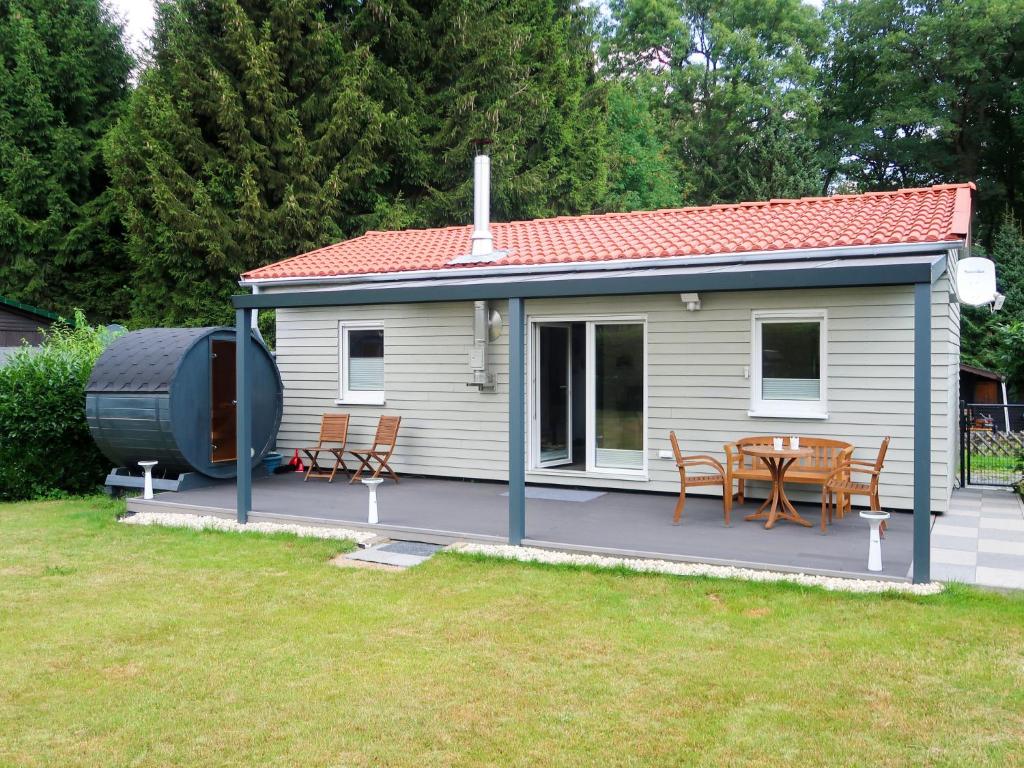 ein Haus mit einer Terrasse mit einem Tisch und Stühlen in der Unterkunft Holiday Home Caro by Interhome in Kirburg