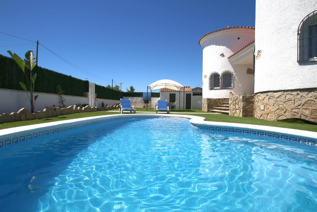 a swimming pool in front of a house at Villa Paradis in Miami Platja