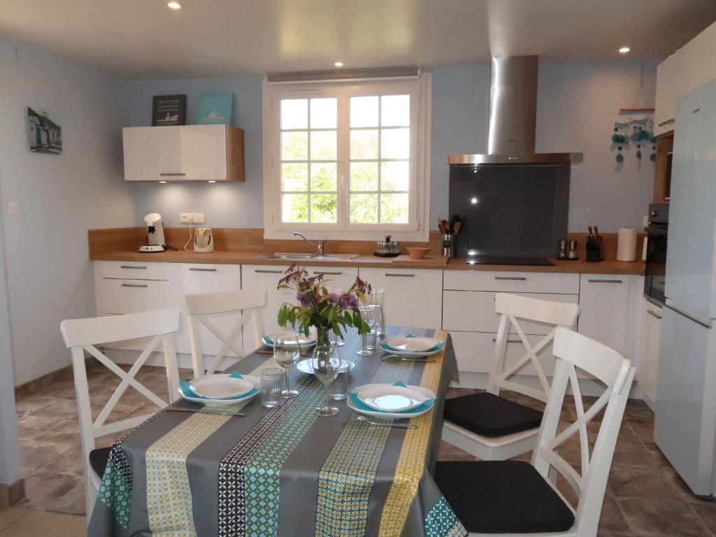 a kitchen with a table with chairs and a tablecloth on it at Holiday Home Penn Ar Bed - PBA114 by Interhome in Pleubian
