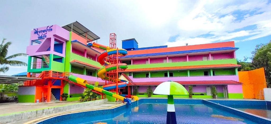 um edifício com um escorrega aquático em frente a uma piscina em Chiang Rai Park Resort em Chiang Rai