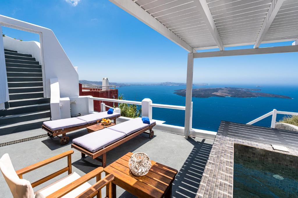 ein Haus mit einem Pool und einer Terrasse mit Bänken in der Unterkunft Iatis View Collection in Imerovigli