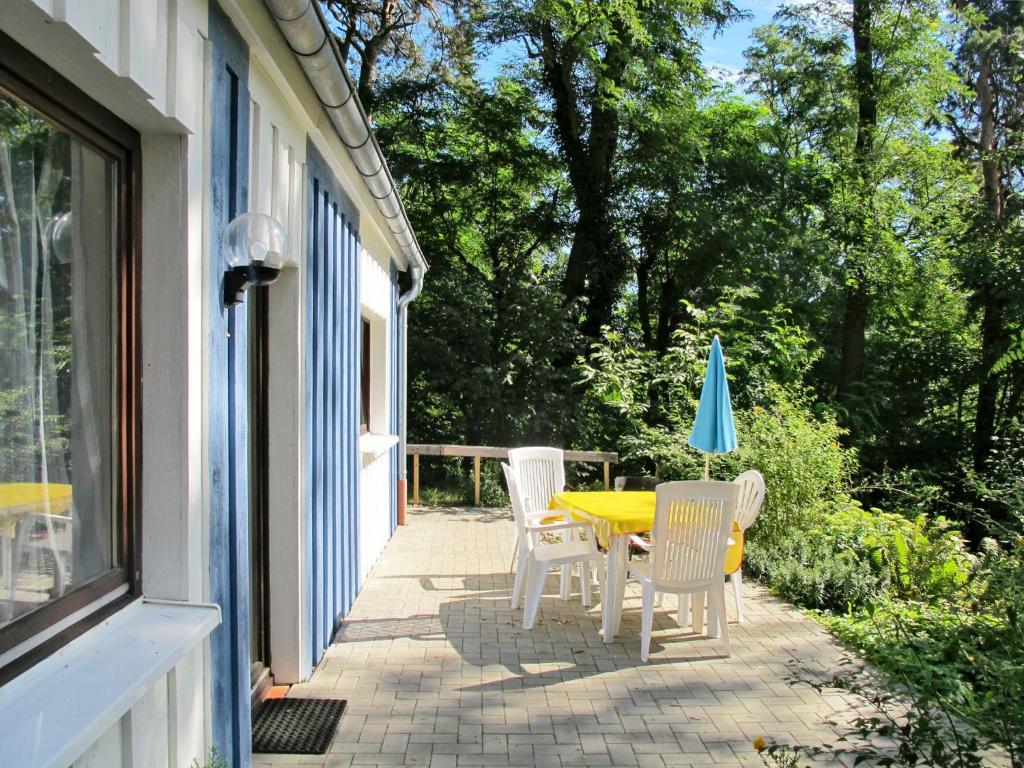 ヒンメルプフォルトにあるHoliday Home Waldhäuser-1 by Interhomeのパティオ(黄色のテーブル、椅子、パラソル付)