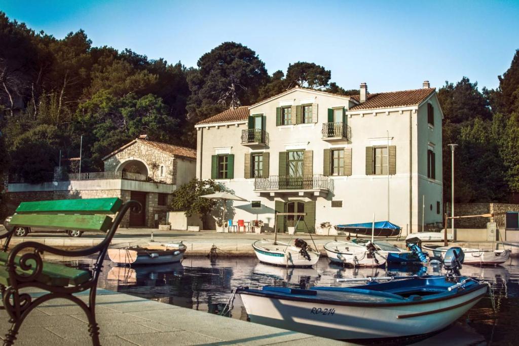a group of boats docked in front of a building at Private luxury Villa del Mar on Solta for up to 10 persons, heated pool, free parking, next to sea! FREE Kajak & Mountainbikes, GREAT living area & privacy! in Rogač
