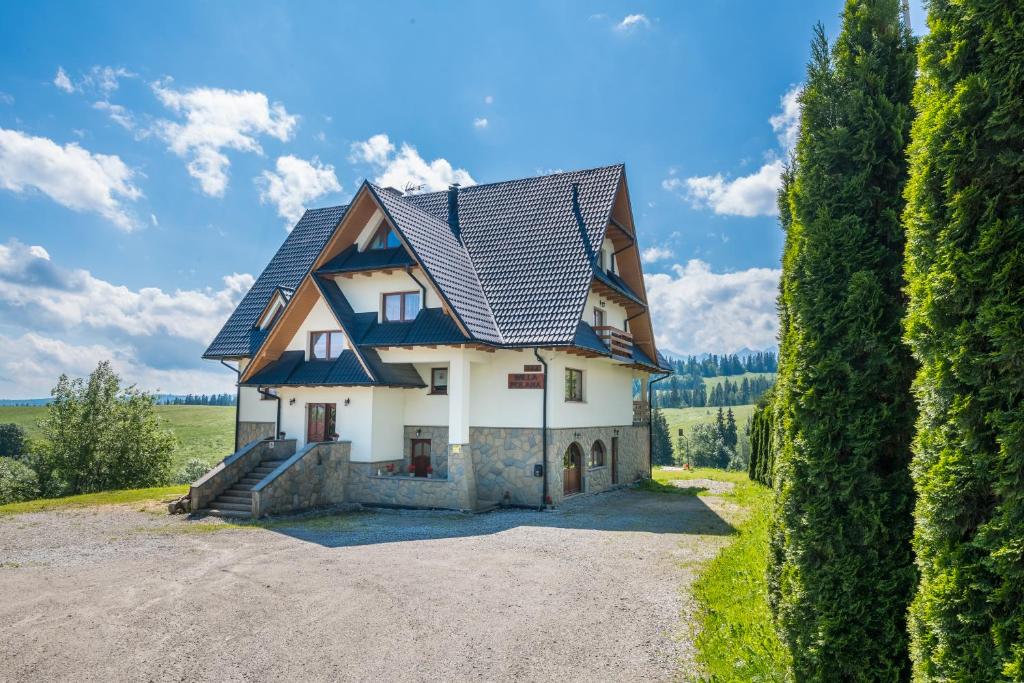 una casa con techo de gambrel en una entrada en Willa Polana, en Bukowina Tatrzańska