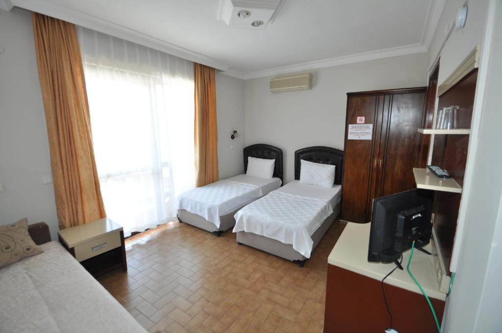 Postel nebo postele na pokoji v ubytování Defne & Zevkim Hotel