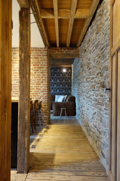 Pokój z kamienną ścianą i drewnianym korytarzem w obiekcie Gîtes le second à Spa (gîte de 2 et de 5 personnes) w mieście Spa
