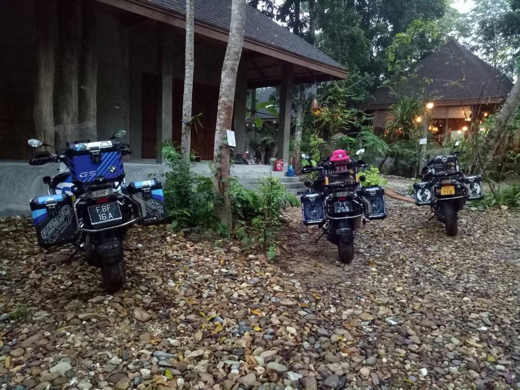 três motos estacionadas em frente a um edifício em Kung Nok Tha Resort Nakhon Si Thammarat em Nakhon Si Thammarat