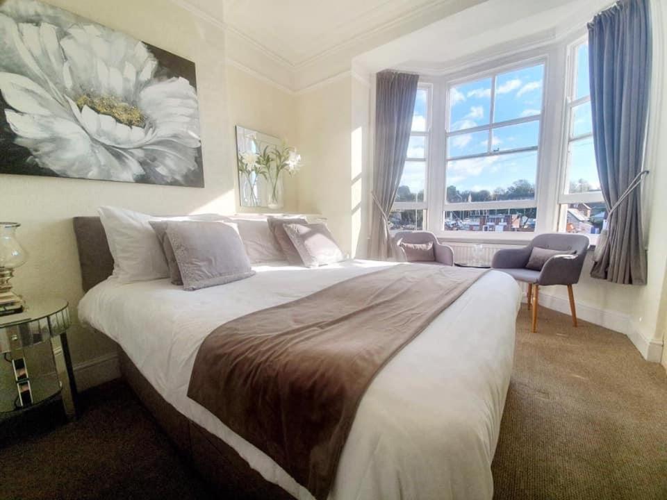 a bedroom with a large bed with a large window at The Chatsworth in Weymouth